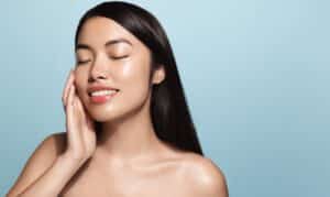 Woman smiling with eyes closed, revealing her lifted, youthful, rejuvenated face from Emface treatment in Navarre, FL.