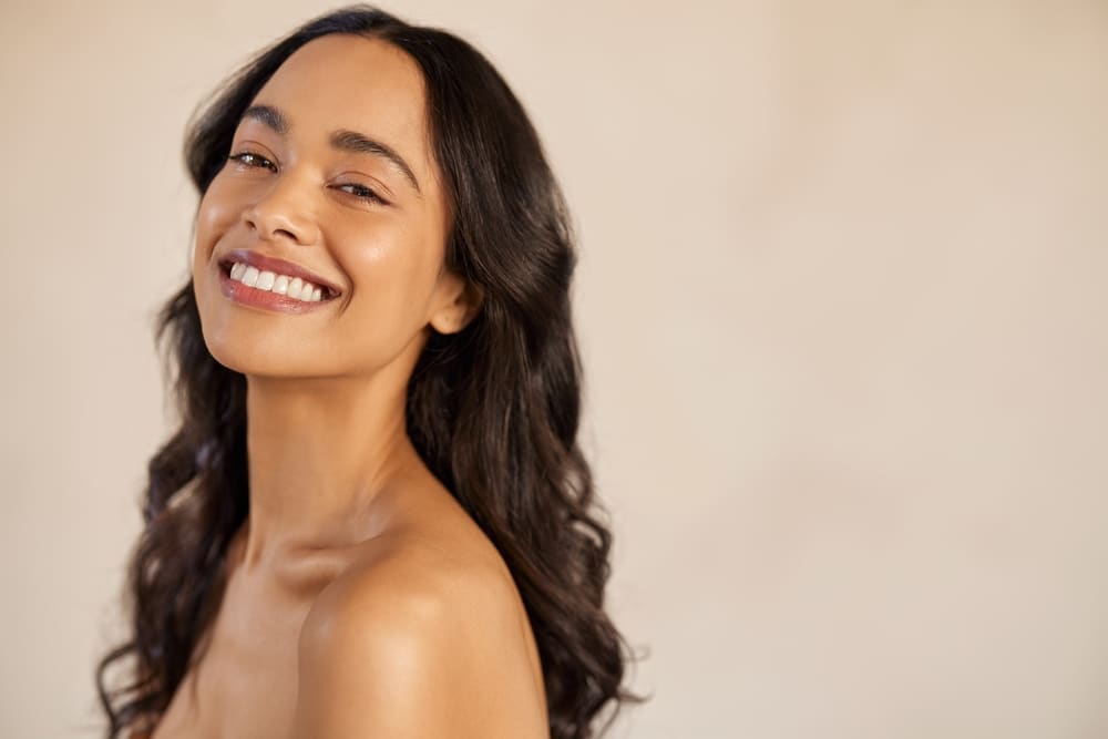 A woman smiling after a SKNLAB derma-facial in Navarre